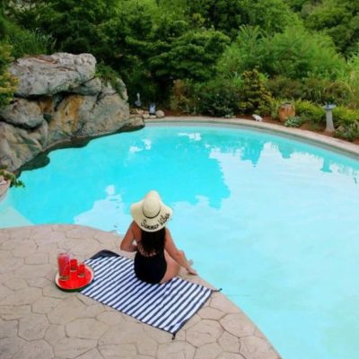 woman sitting on towel at pool