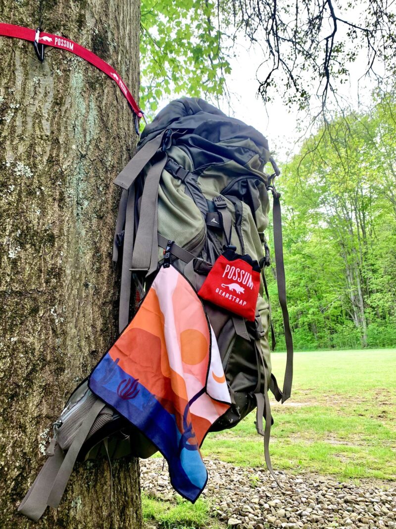 photo of backpack and washcloth hanging from a tree with a possum gearstrap